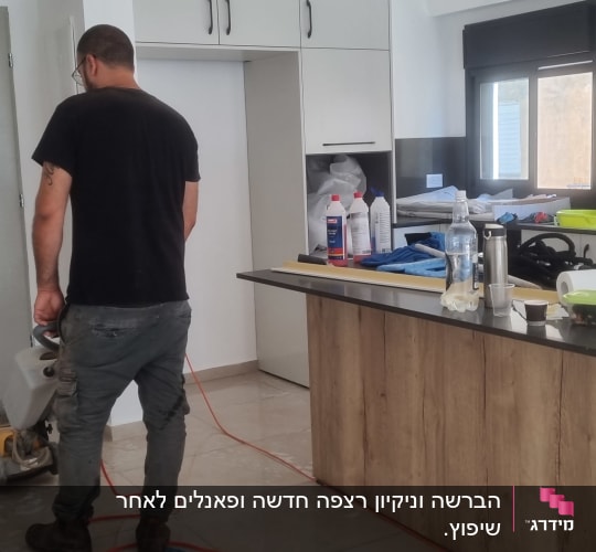 אדם מנקה רצפה עם מכונת פוליש במטבח